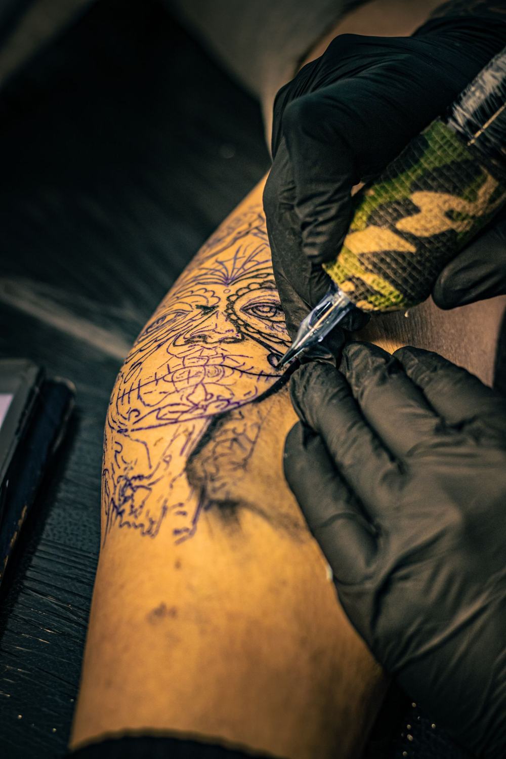 Tatuagem em andamento sob luz quente